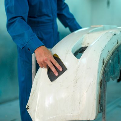 worker-sands-car-bumper-in-repair-shop-2026-03-17-04-24-41-utc